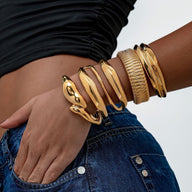 Bracelet manchette doré en acier inoxydable, design texturé avec surface lisse et motifs entrelacés, style moderne et.