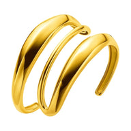 Bracelet manchette doré en acier inoxydable avec design sculpté et formes courbes audacieuses.