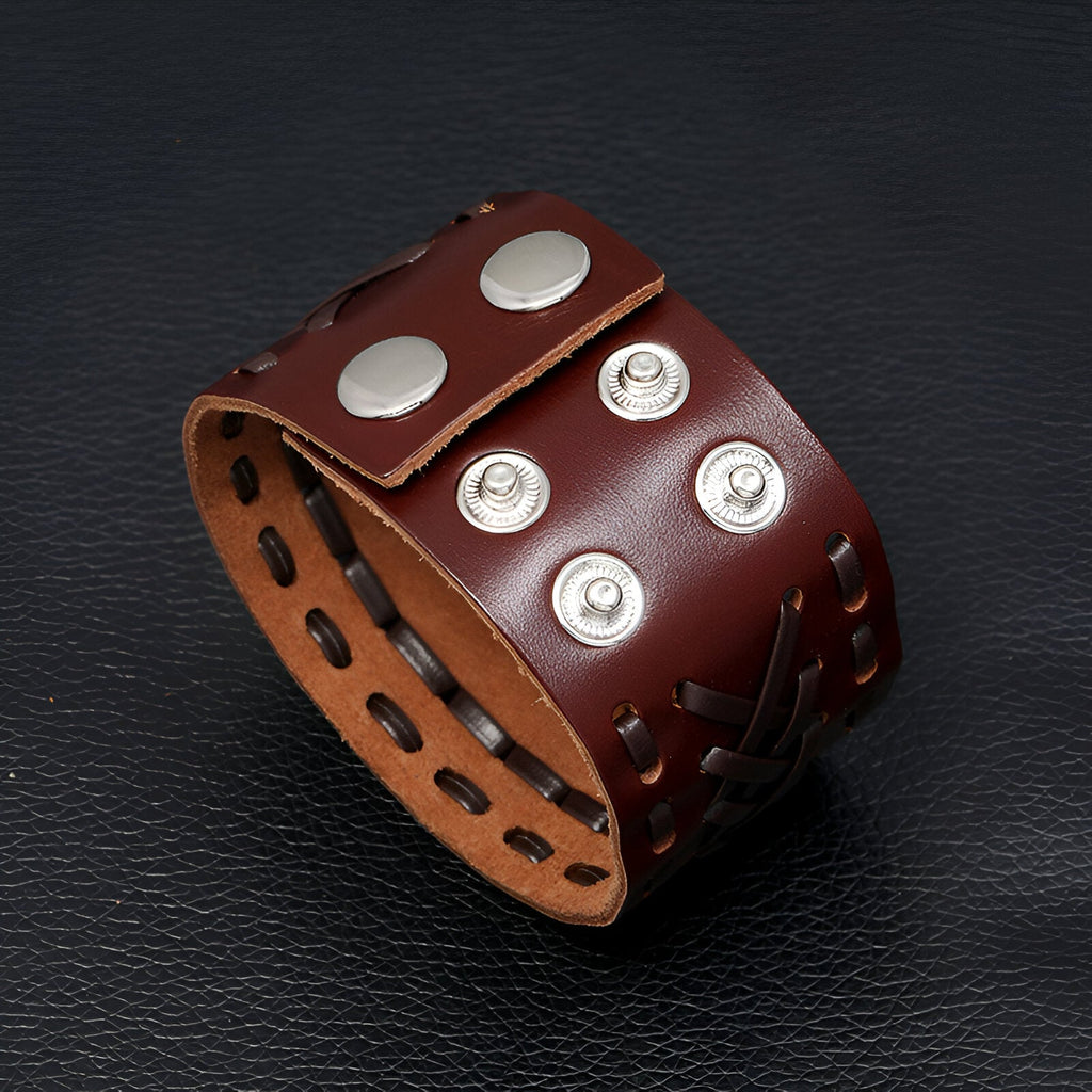 Bracelet manchette homme en cuir marron tissé avec quatre boutons-pression métalliques argentés.
