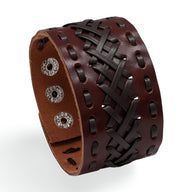 Bracelet manchette large en cuir marron tressé avec fermoir à boutons-pression métalliques.