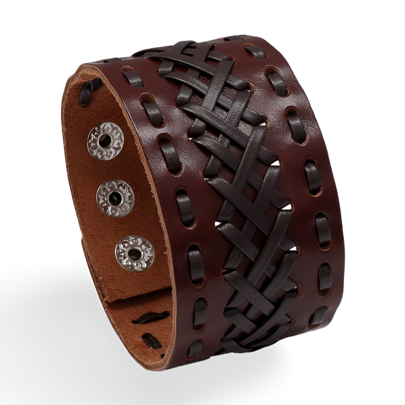 Bracelet manchette large en cuir marron tressé avec fermoir à boutons-pression métalliques.