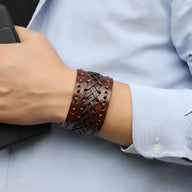 Bracelet manchette en cuir marron tissé avec détails perforés pour homme.