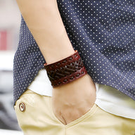 Bracelet manchette en cuir marron tressé style nordique pour homme sur poignet.