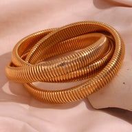 Bracelet manchette trio Oriane en métal doré à effet ressort flexible.