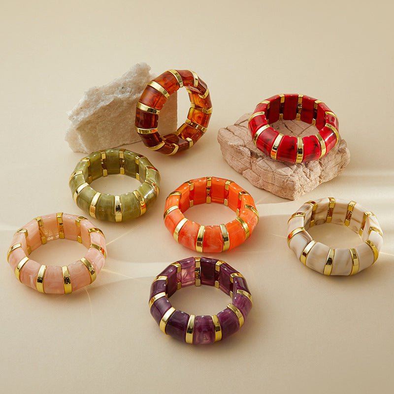 Bracelets manchette épais en acrylique avec inserts dorés, couleurs variées, style chic et moderne.