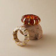 Bracelet manchette épais marron en acrylique avec anneaux dorés, design chic et contemporain.