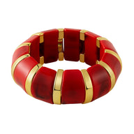 Bracelet manchette épais en acrylique rouge avec intercalaires dorés élégants.