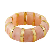 Bracelet manchette épais en acrylique rose avec larges plaques et détails dorés élégants.