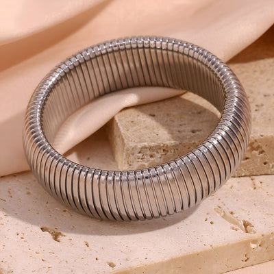 Bracelet manchette flexible en maille argentée, design épuré et moderne.