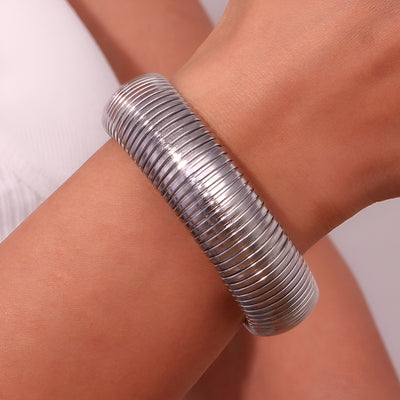 Bracelet manchette flexible en maille argentée, design moderne et élégant.