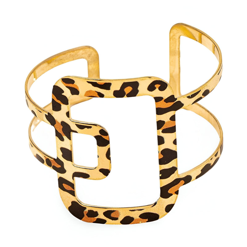 Bracelet manchette en métal doré orné d'un motif léopard stylisé au centre.
