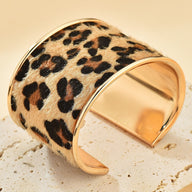 Bracelet manchette doré avec motif léopard en cuir, style large et incurvé.