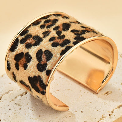 Bracelet manchette doré avec motif léopard en cuir, style large et incurvé.