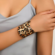 Bracelet manchette large en métal doré avec motif léopard noir et marron pour femme.