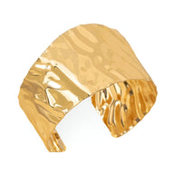 Bracelet manchette ondulé en alliage métallique doré avec surface texturée brillante.