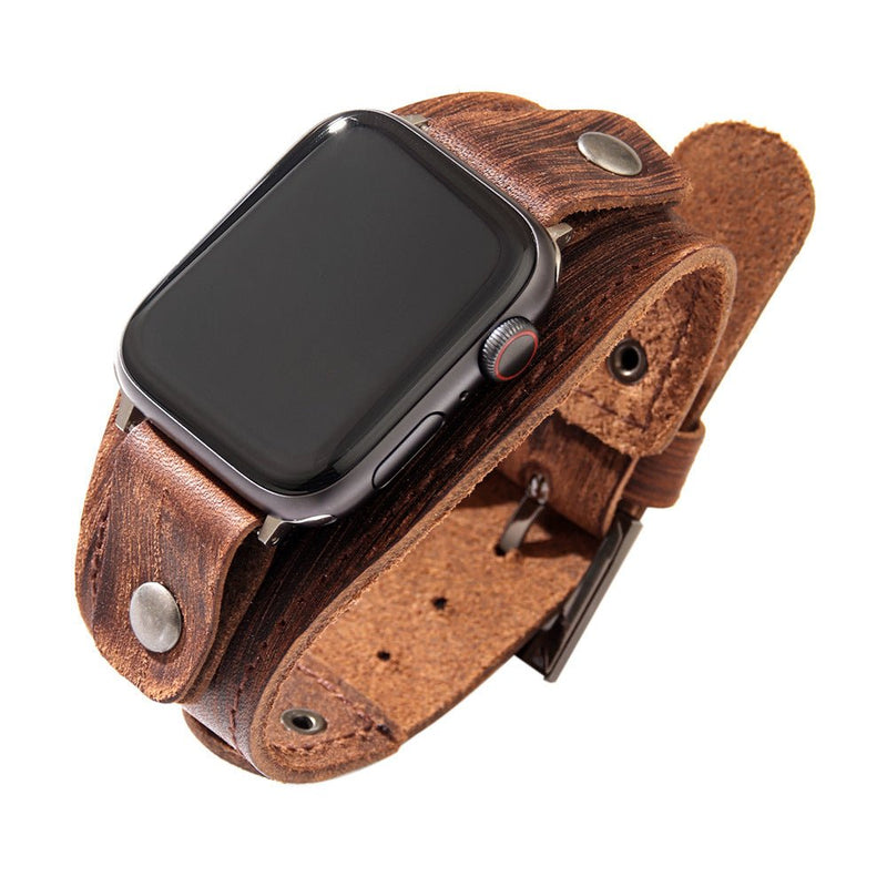 Bracelet manchette large en cuir marron avec boucle et rivets pour Apple Watch.