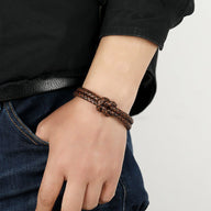 Bracelet masculin en simili cuir marron tressé avec nœud central et fermeture magnétique en acier inoxydable.