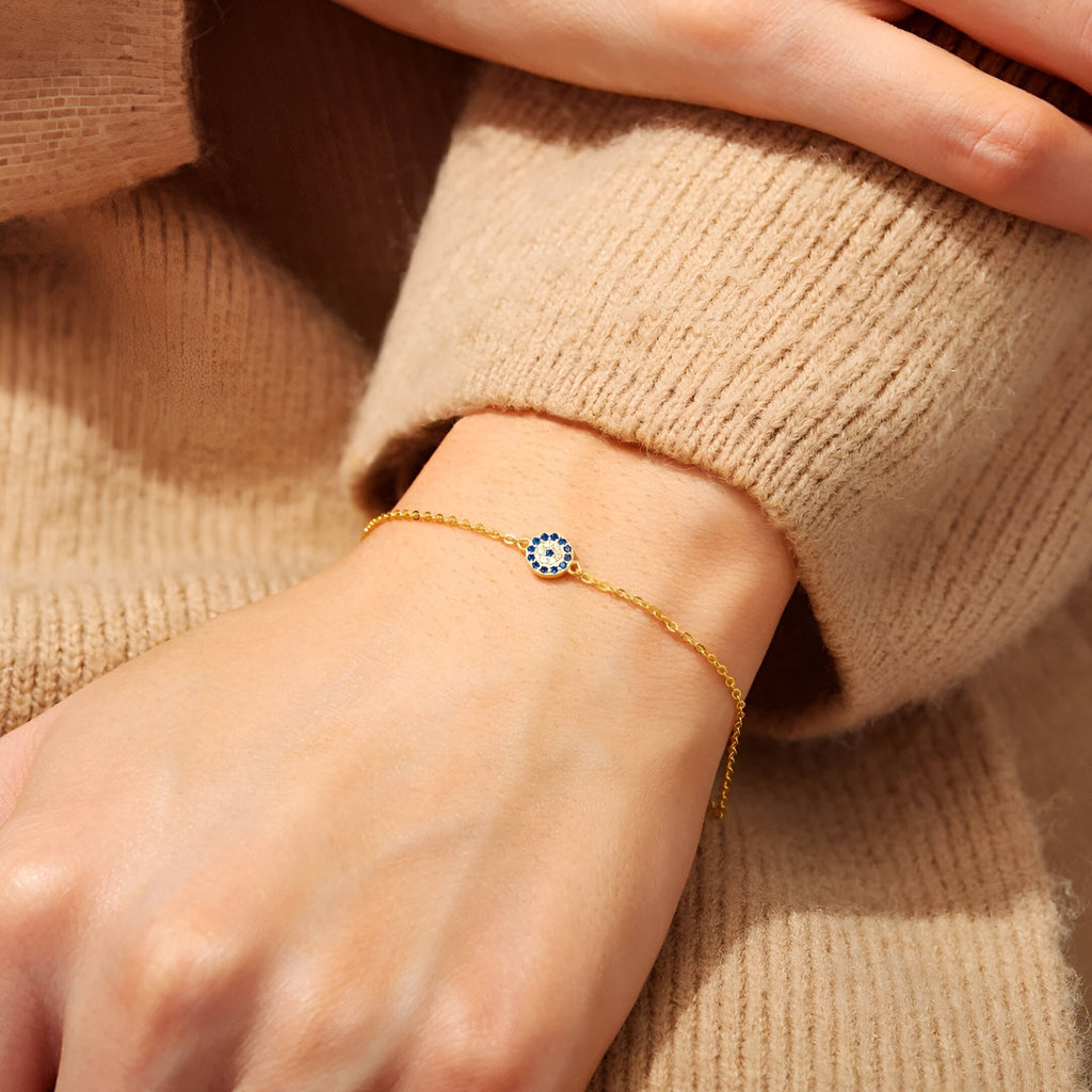 Bracelet fin en or avec pendentif œil bleu et blanc sur chaîne délicate pour femme.