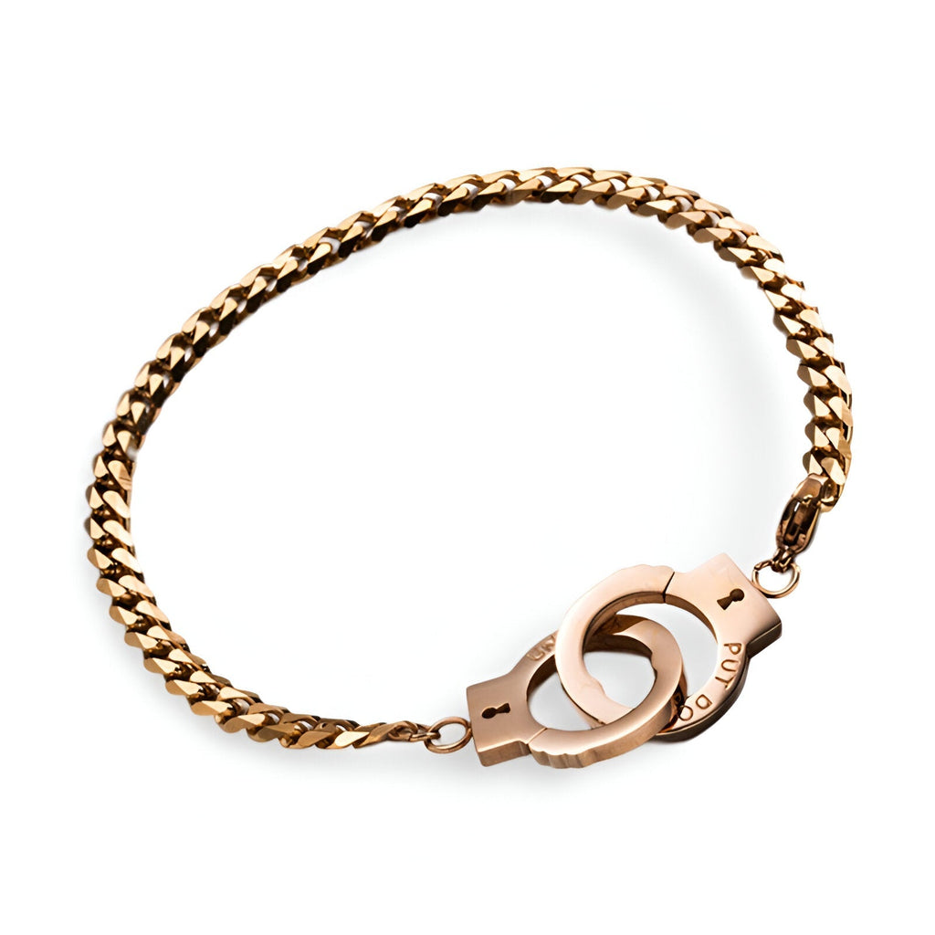 Bracelet en acier inoxydable or rosé avec menottes détaillées et chaîne épaisse.