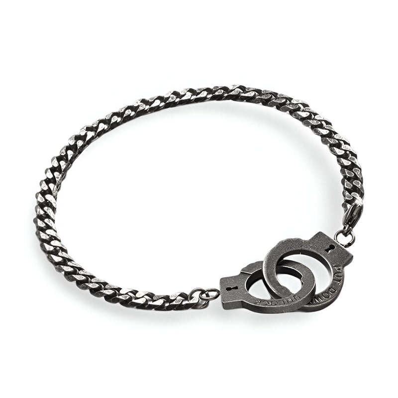 Bracelet menottes en acier inoxydable gris avec chaîne maillons plats et fermoir menottes stylisé.