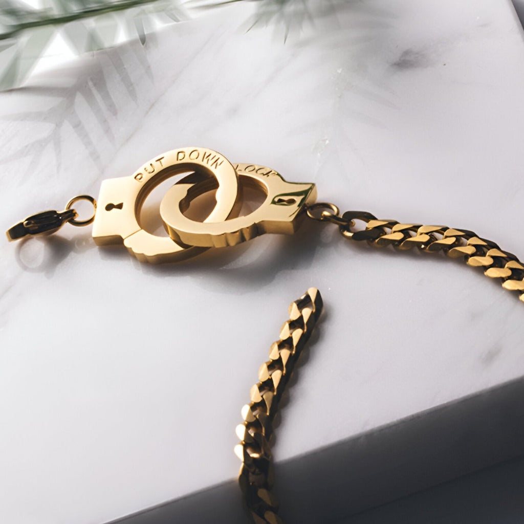 Bracelet menottes en acier inoxydable or rose avec maillons plats et fermoir original entrelacé.