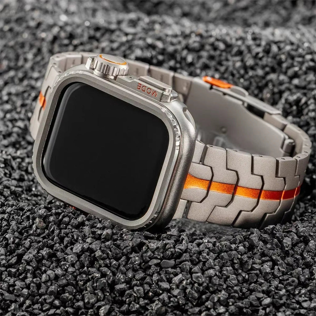 Bracelet montre Apple en titane gris avec maille robuste et ligne orange centrale, boucle déployante robuste.