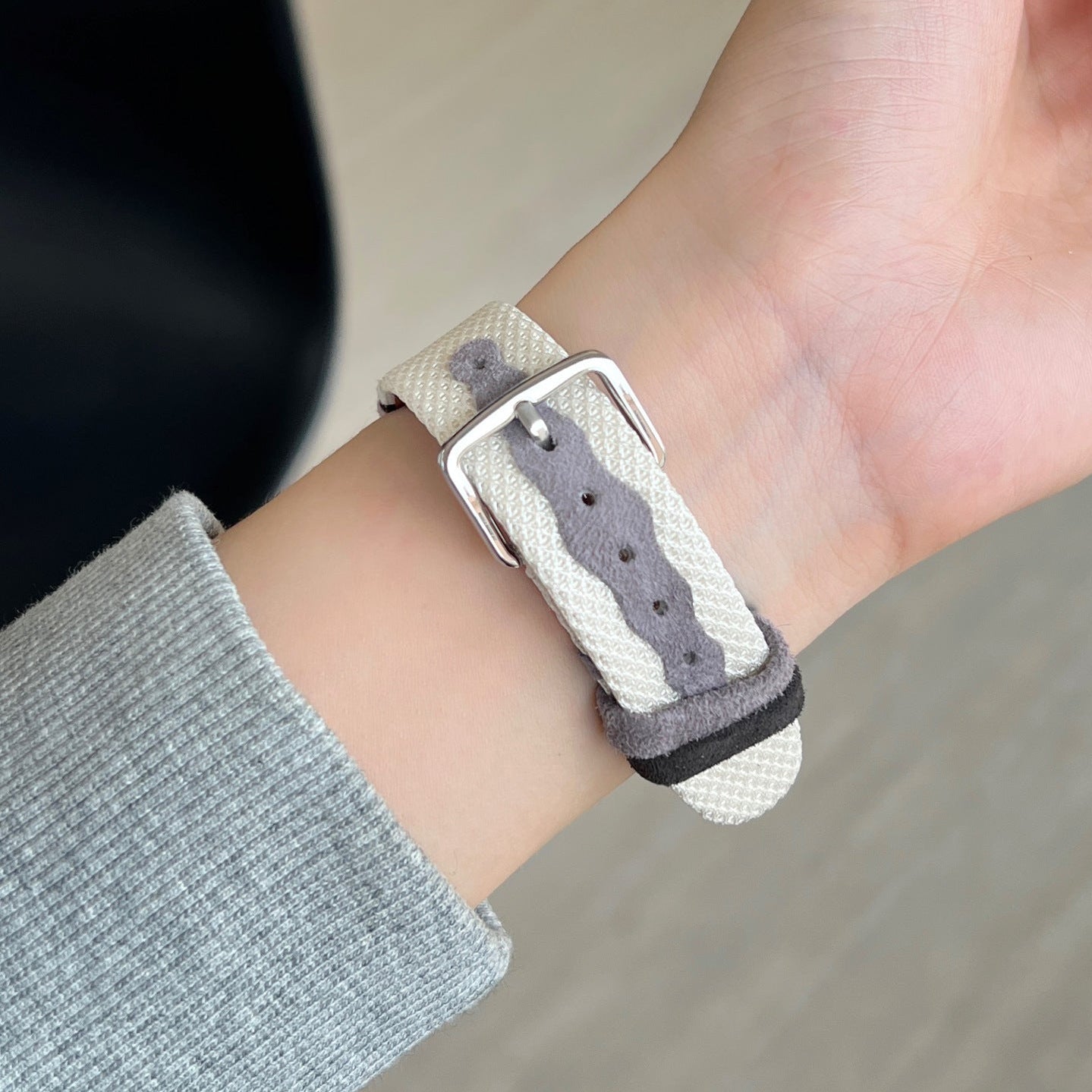 Bracelet Apple Watch en toile tissée grise et beige, boucle argentée, intérieur cuir doux, style épuré et confortable.