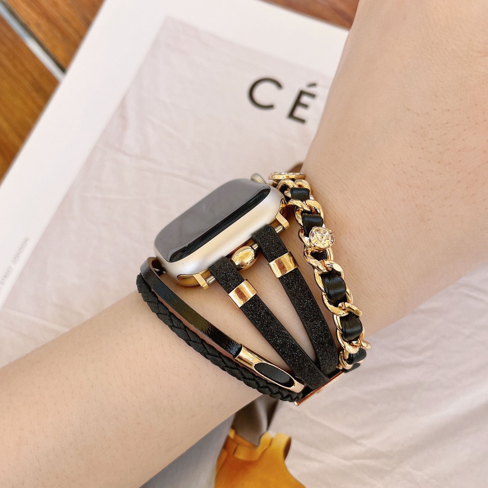 Bracelet montre Apple Watch femme simili tressé et chaîne dorée, bijou élégant avec strass et finitions brillantes, modèle Wixe