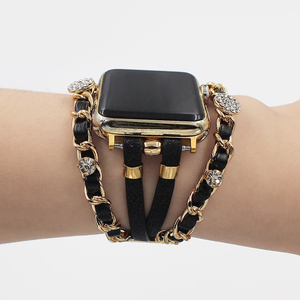 Bracelet montre Apple Watch simili cuir noir avec chaîne dorée et strass brillants, style double tour élégant.