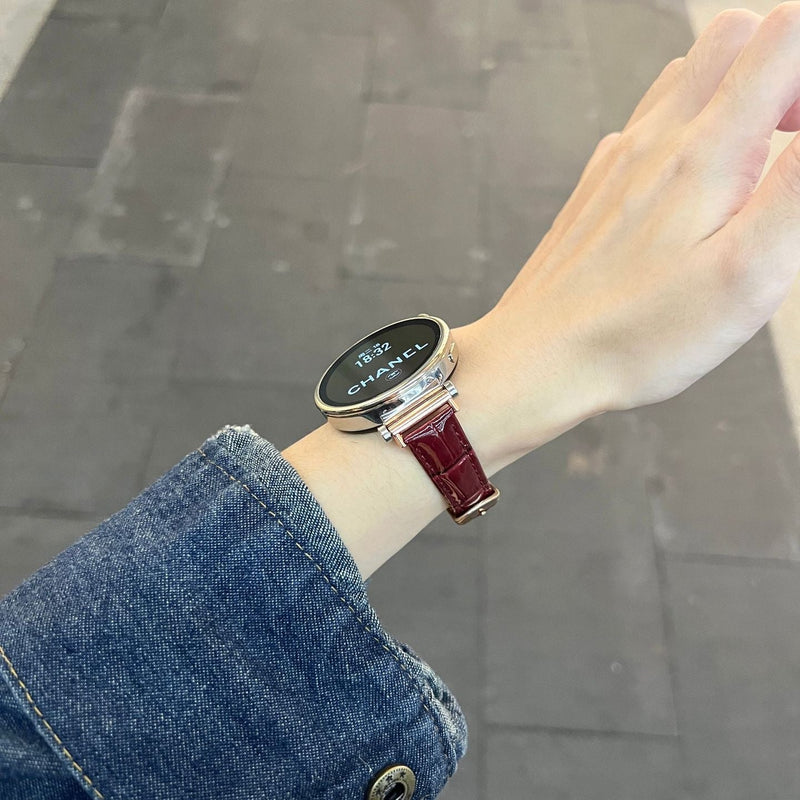 Bracelet montre rouge effet crocodile en simili vegan avec boucle métal doré, porté au poignet féminin.