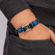 Bracelet marin pour homme en corde nautique noire à motifs blancs, fermoir mousqueton argenté et détail bleu vif.