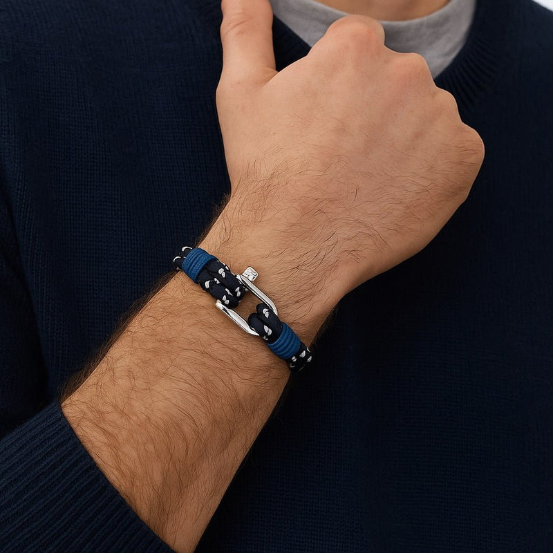Bracelet marin bleu marine en corde nautique avec fermoir mousqueton argenté et détails blancs.