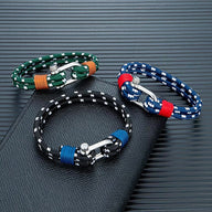 Trois bracelets marins en corde nautique avec mousquetons métal, couleurs vert, bleu, noir et touches rouges et orange.