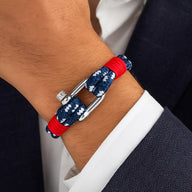 Bracelet marin en corde nautique bleue à motifs blancs, fermoir mousqueton argenté, détails rouges, style tendance homme.