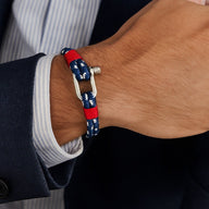 Bracelet marin en corde nautique bleue à motifs blancs et détails rouges avec mousqueton en métal argenté.