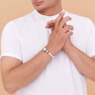 Bracelet mousqueton beige en coton avec détail drapeau français en acier inoxydable, porté au poignet.