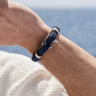 Bracelet homme bleu marine en coton tressé avec mousqueton en acier inoxydable sur poignet.