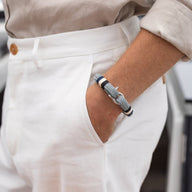 Bracelet homme en coton bleu marine avec fermoir mousqueton en acier inoxydable porté au poignet.