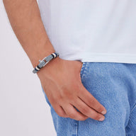 Bracelet mousqueton gris en coton et acier inoxydable porté au poignet, style masculin moderne.