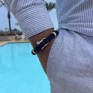 Bracelet homme bleu marine en coton avec fermoir mousqueton en acier inoxydable, porté au poignet.