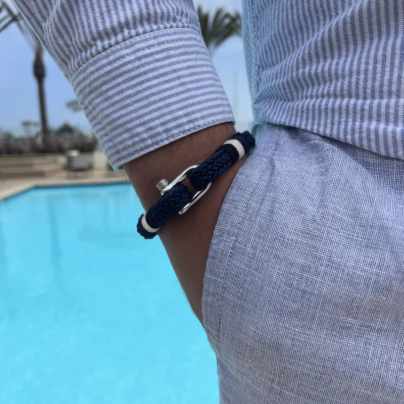 Bracelet homme bleu marine en coton avec fermoir mousqueton en acier inoxydable, porté au poignet.