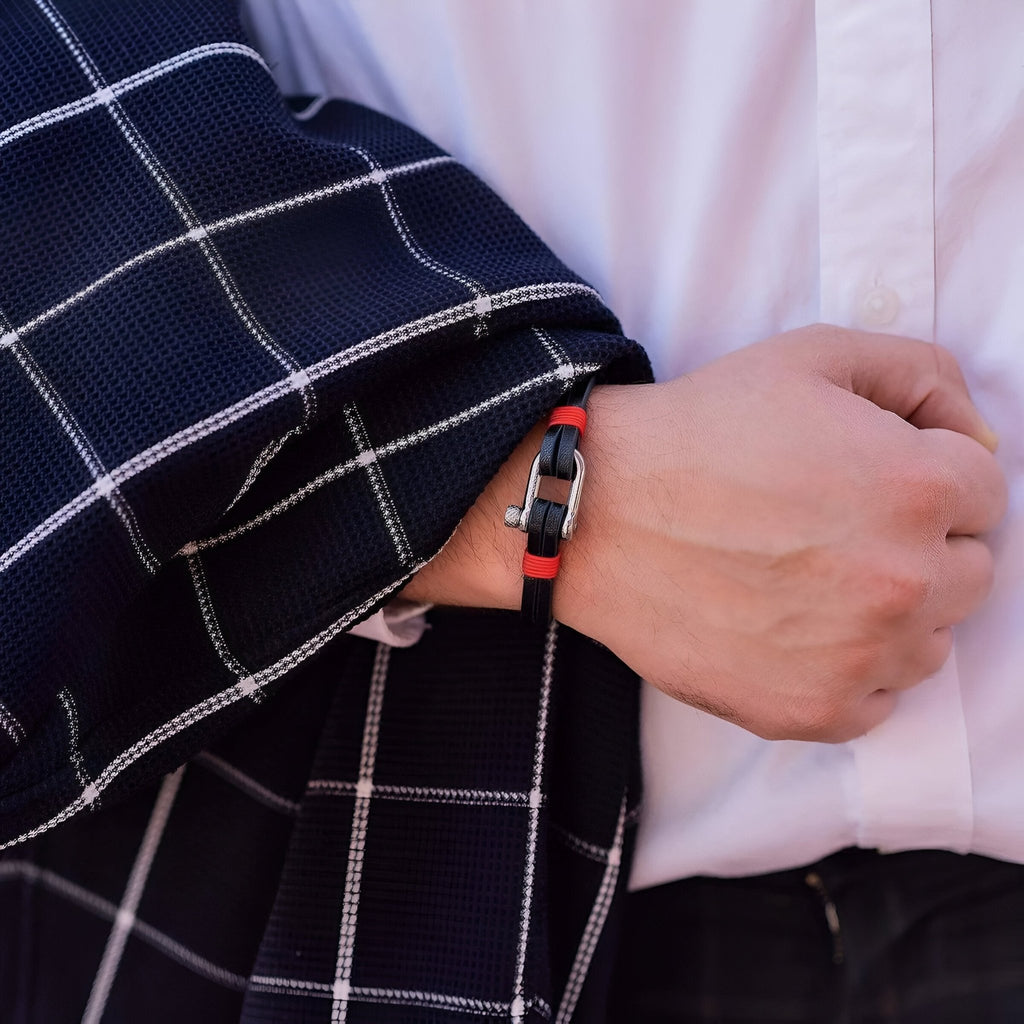 Bracelet homme cuir noir et rouge avec mousqueton en acier inoxydable porté au poignet.
