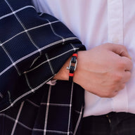 Bracelet homme cuir noir et rouge avec mousqueton en acier inoxydable porté au poignet.