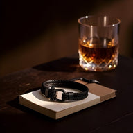 Bracelet homme noir en cuir tressé avec fermoir mousqueton en acier inoxydable, style moderne.