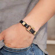 Bracelet homme en cuir noir avec mousqueton en acier doré, style robuste et moderne.