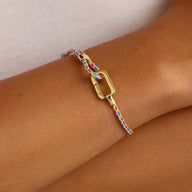Bracelet ajustable en nylon multicolore avec fermoir mousqueton en acier doré.