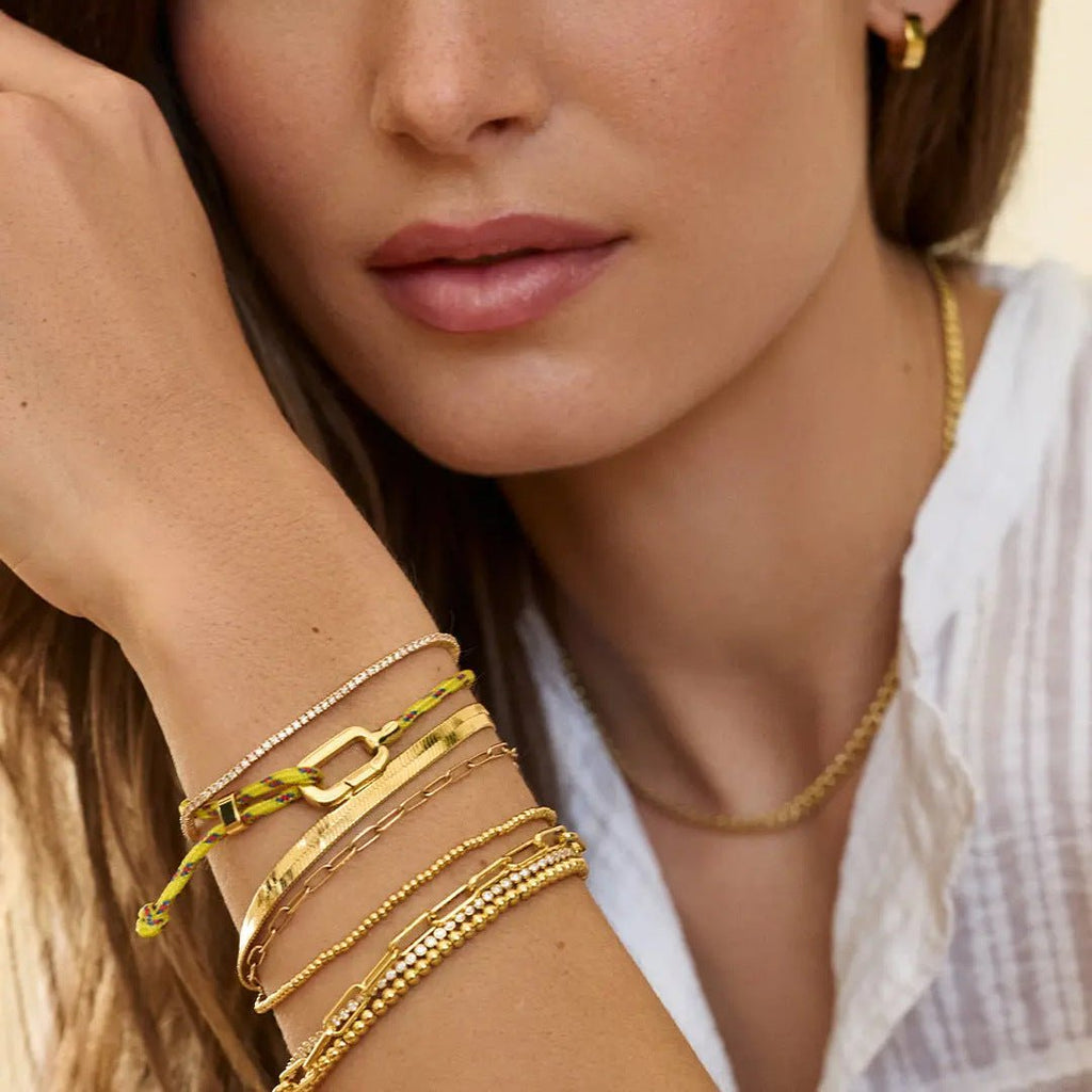 Bracelet mousqueton en nylon jaune avec maillons en acier inoxydable, style ajustable et moderne.