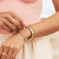 Bracelets en nylon beige et acier inoxydable avec mousqueton, style ajustable et moderne sur poignet féminin.