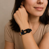 Bracelet noir en nylon avec mousqueton en acier et fil ciré arc-en-ciel, porté au poignet.