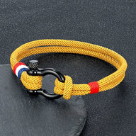 Bracelet homme en fil ciré jaune avec mousqueton noir et détails bleu blanc rouge.